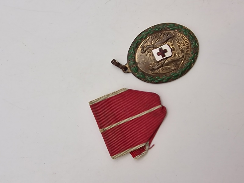 Original  østrigsk Røde Kors Fortjenstmedalje fra Første Verdenskrig, også kendt som "Decoration for Services to the Red Cross" (Ehrenzeichen für Verdienste um das Rote Kreuz). 