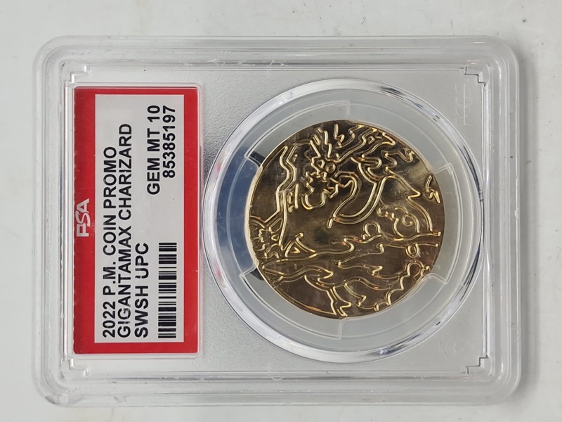 2022 P.M. Coin Promo Gigantamax Charizard mønt fra Pokémon Trading Card Game. Denne guldfarvede mønt blev udgivet som en del af en promo-udgivelse i 2022 og viser Charizard i sin Gigantamax-form.
