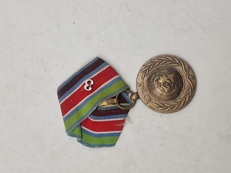 Original FN-medalje, som er en international dekoration tildelt af De Forenede Nationer (FN) til militært og politimæssigt personale, der har deltaget i FN-operationer. 