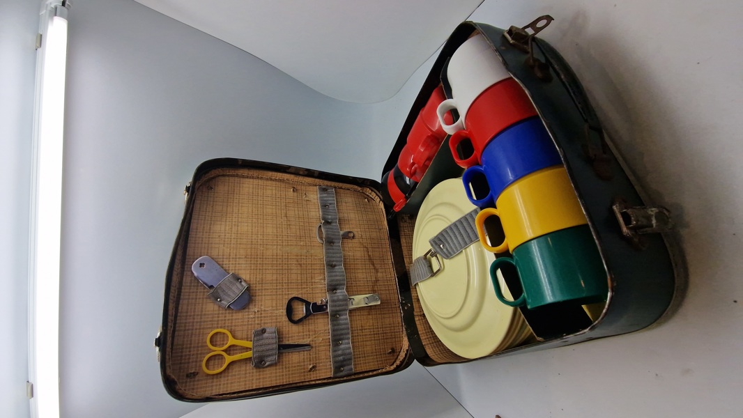 vintage picnickuffert, der indeholder service til flere personer.