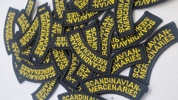broderede navnemærker med teksten "SCANDINAVIAN MERCENARIES"