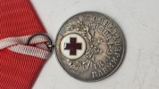 Dansk Røde Kors Fortjenstmedalje, som blev indstiftet i 1927 og tildeles for fortjenstfuld indsats for Røde Kors. Original 